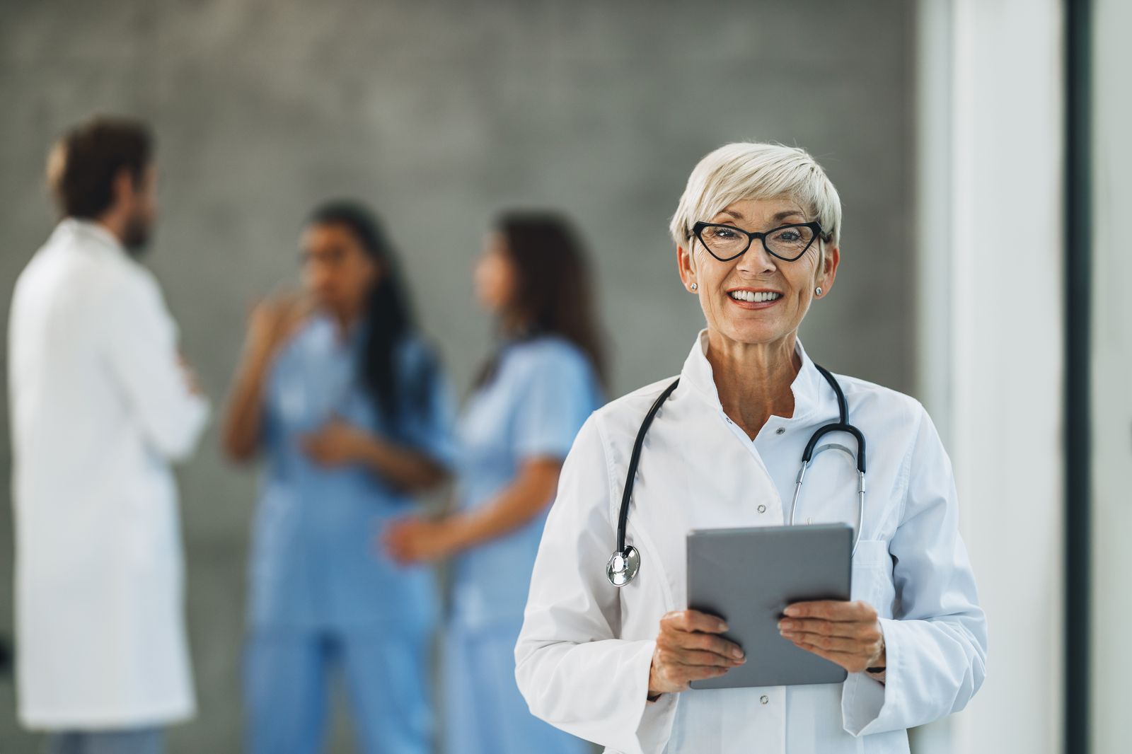 EHR and EMR Support Doctor using tablet in hospital hallway - EHR and EMR support services