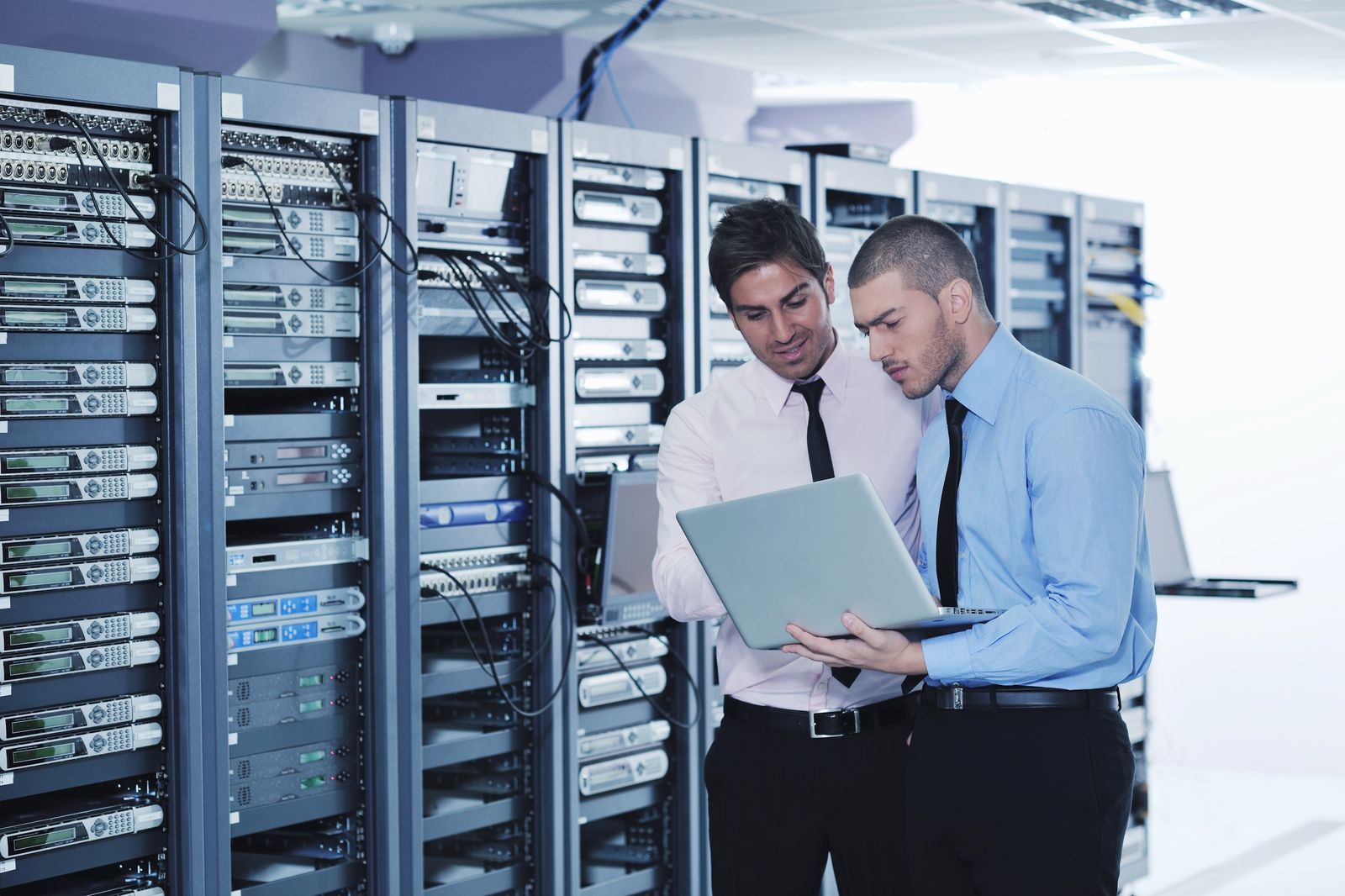 IT engineers reviewing network in server room - healthcare IT management