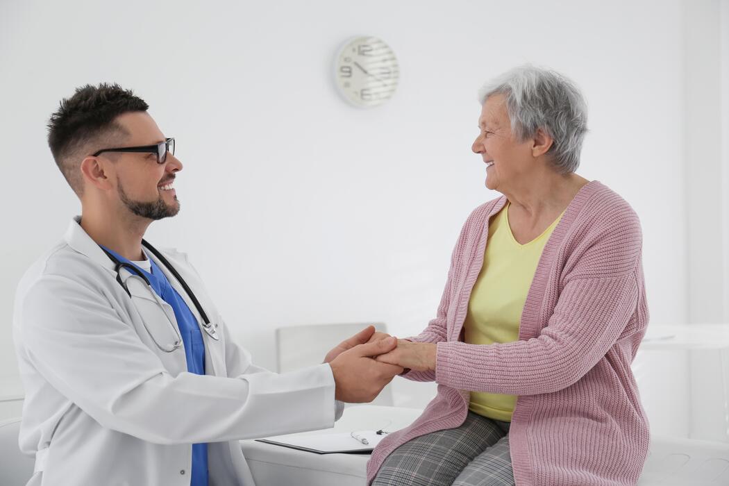 Movement disorders clinic IT support Neurologist examining an elderly patient hands at a movement disorders clinic