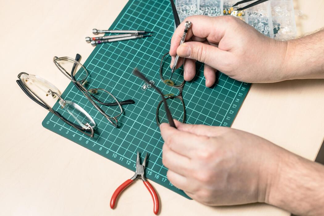 Optical lab IT support Optician working on eyeglasses with precision tools in an optical lab