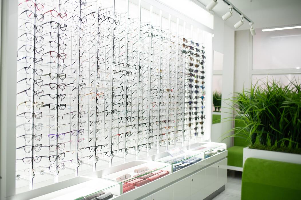 Optical retailer IT support Wall of eyeglasses frames on display in a modern optical retail shop