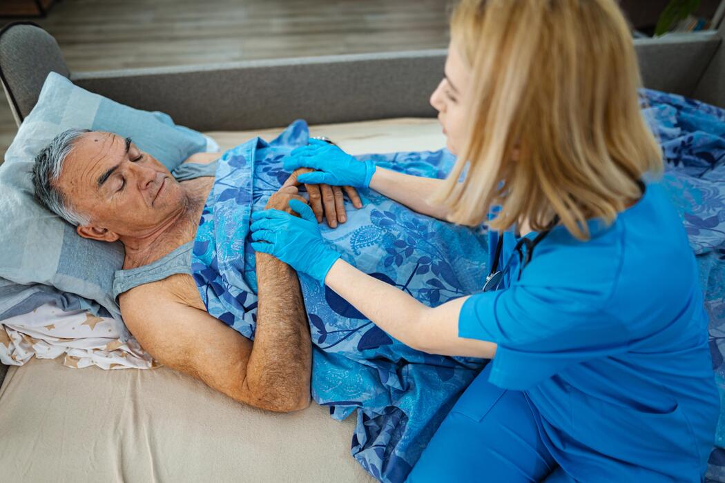 Caregiver providing comfort to a seriously ill patient during a palliative care visit