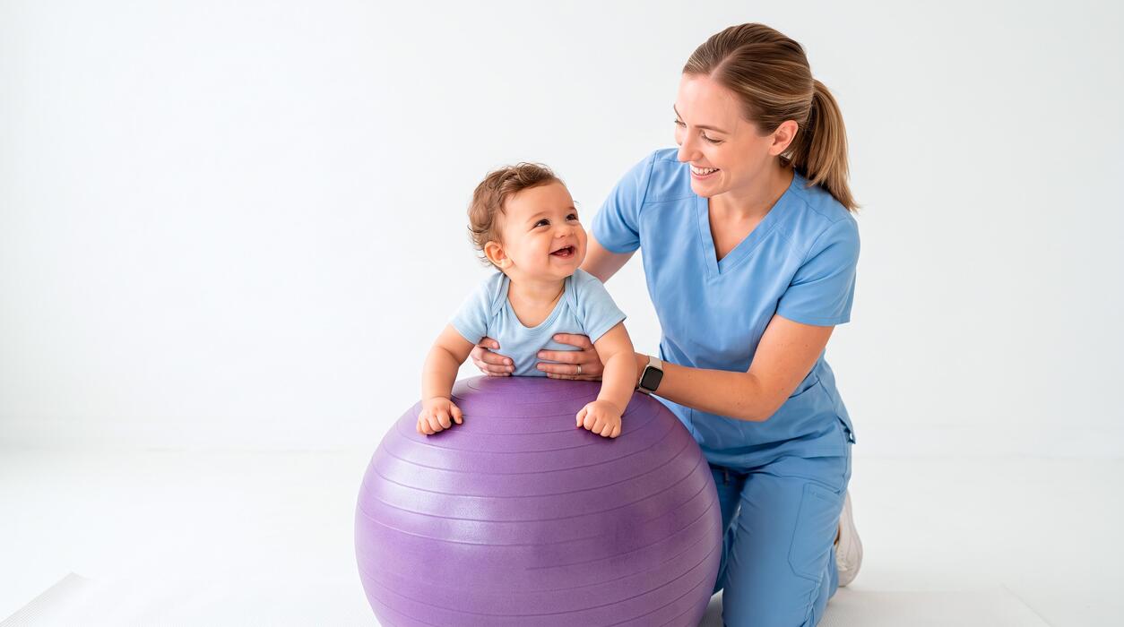 Pediatric therapist guiding a baby through exercises on a therapy ball at a childrens therapy clinic