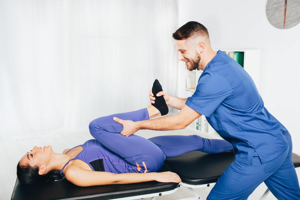 Physiotherapist guiding a woman through a hip and pelvic rehabilitation exercise at a pelvic floor therapy clinic