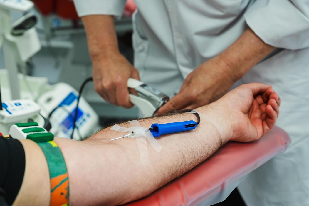 Phlebotomy services IT support Phlebotomist performing a venipuncture blood draw on a patient arm at a phlebotomy service
