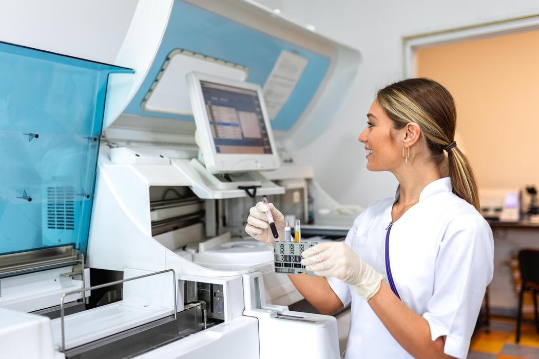 Reference laboratories IT support Laboratory technician loading specimens into a high-throughput chemistry analyzer at a reference laboratory
