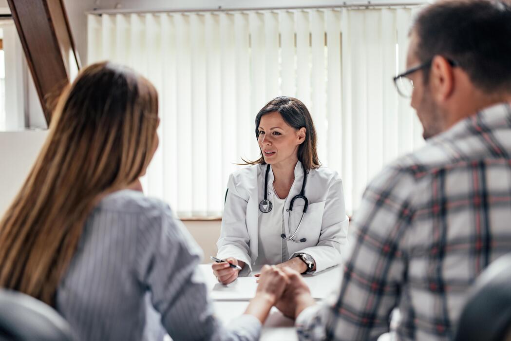 Fertility physician consulting with a couple about their treatment at a reproductive endocrinology practice