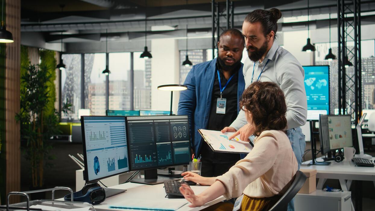 Medical billing and coding team collaborating at computers in a revenue cycle management firm