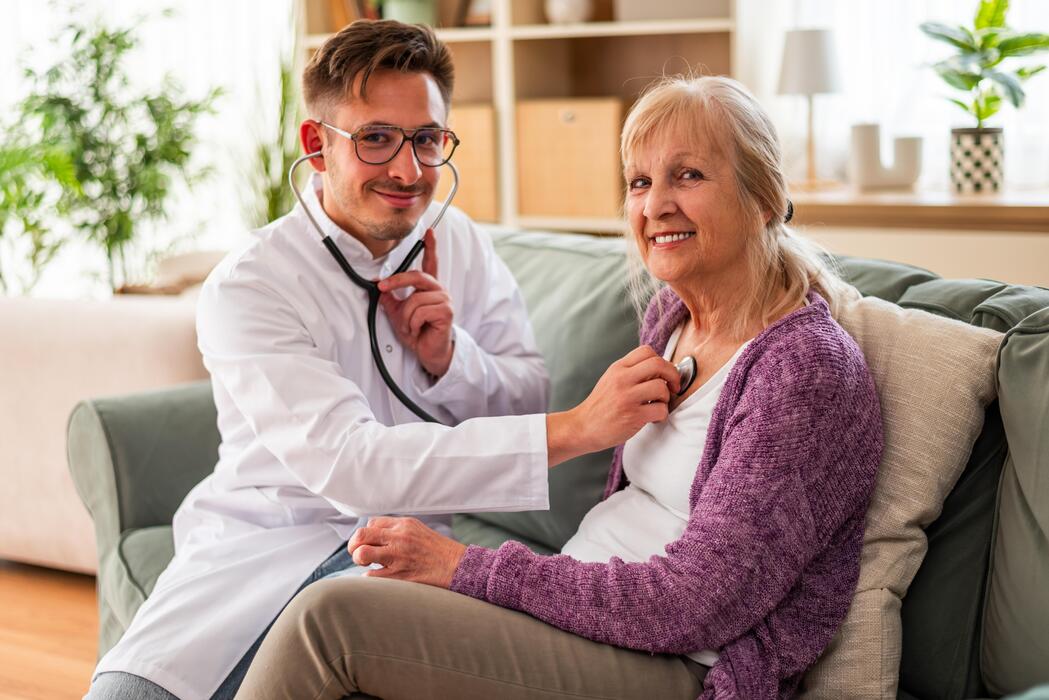 Primary care clinician examining an elderly patient with a stethoscope at a rural health clinic