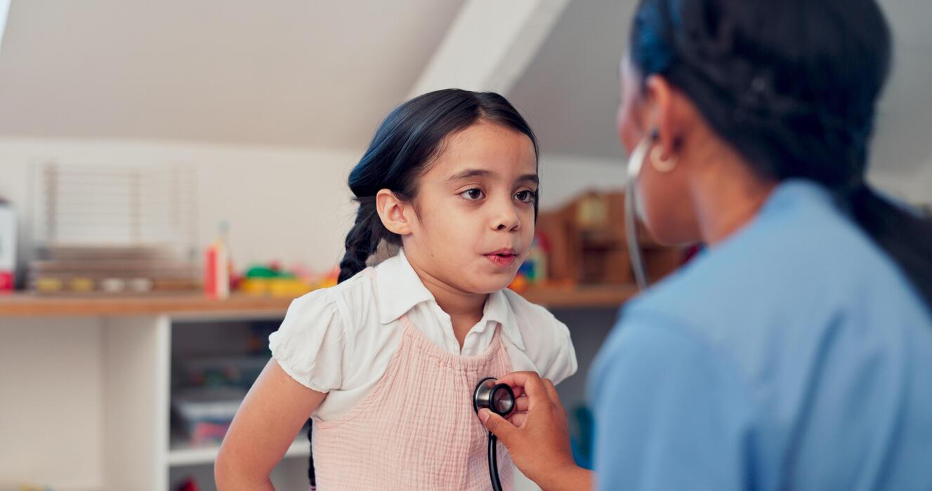 School health center nurse examining a student with a stethoscope during a visit