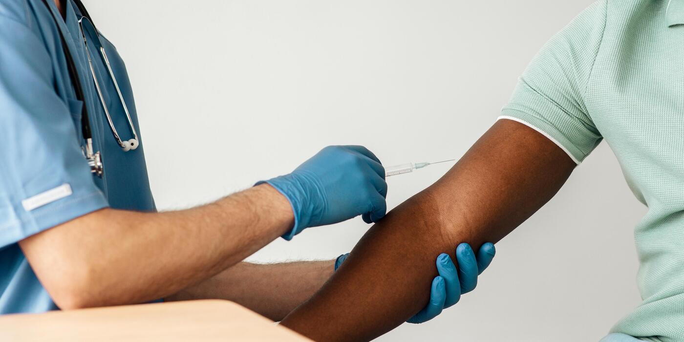 Clinician administering a travel vaccine injection to a patient