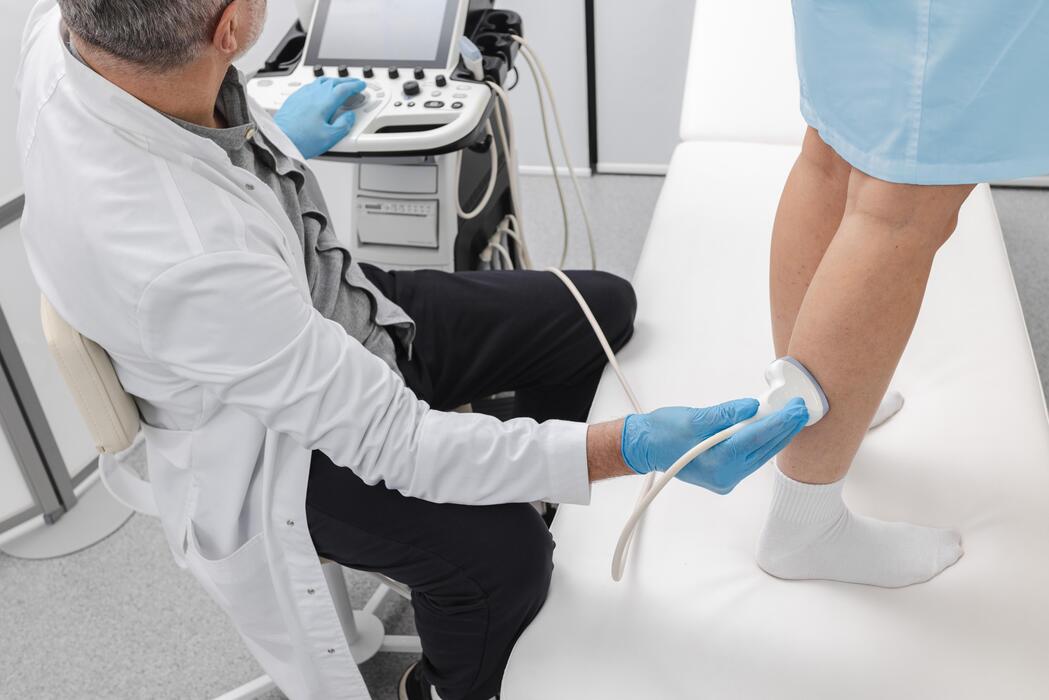 Sonographer performing a venous duplex ultrasound on a patient leg