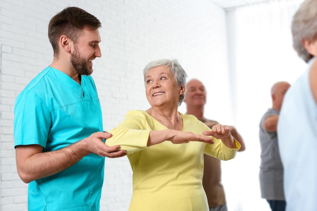 IT Services for Vestibular Therapy Clinics Care worker assisting an elderly patient during balance and vestibular therapy