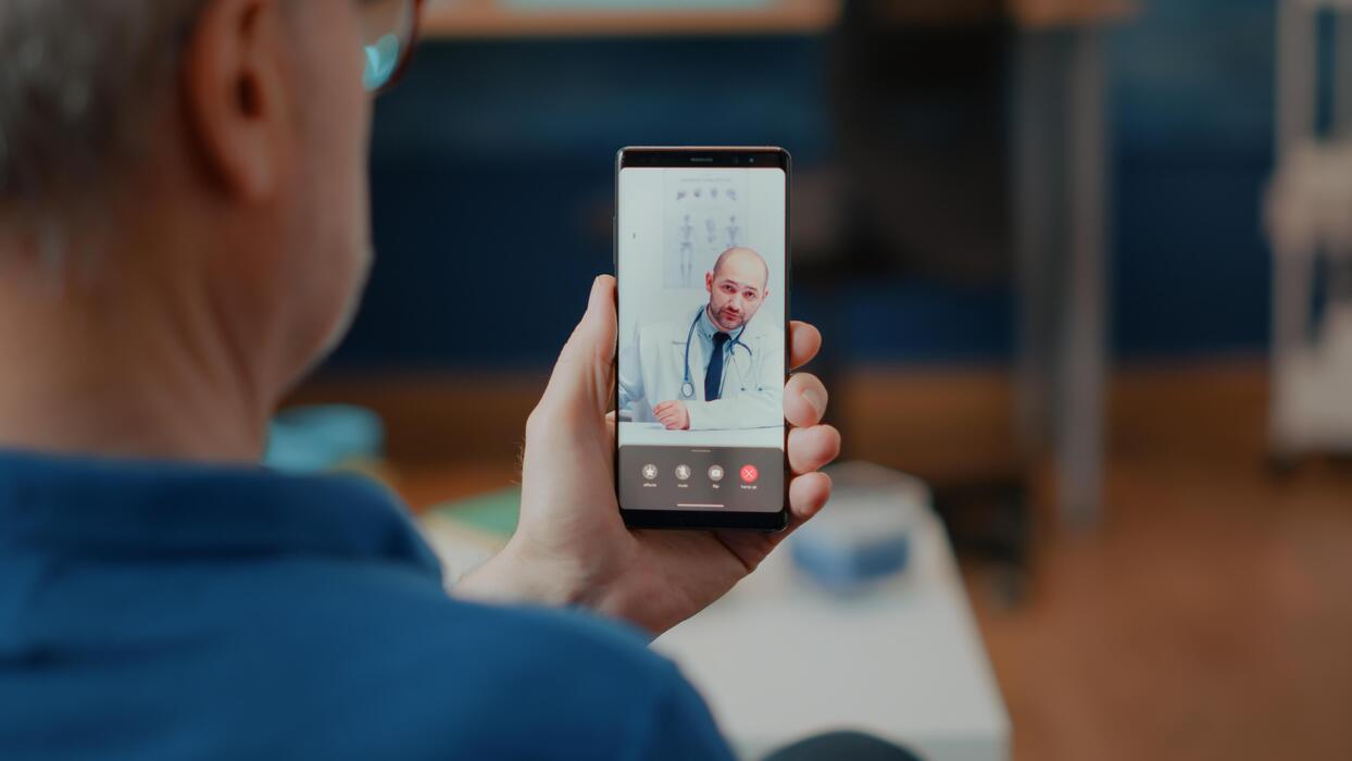 IT Services for Virtual Care Clinics Senior patient on a telemedicine video call with a doctor at a virtual care clinic
