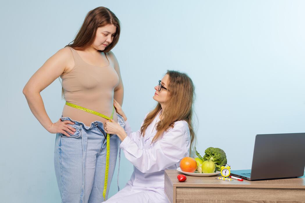 IT Services for Weight Loss and Wellness Centers Nutritionist measuring a patient waist during a weight loss consultation at a wellness center